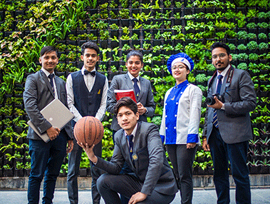 Inspiria students by the green wall
