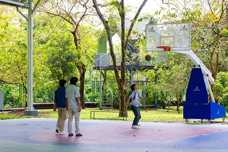 Students playing on the outdoor basketball court