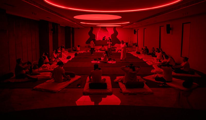 Guided wellness and recovery session in the red-lit relaxation studio